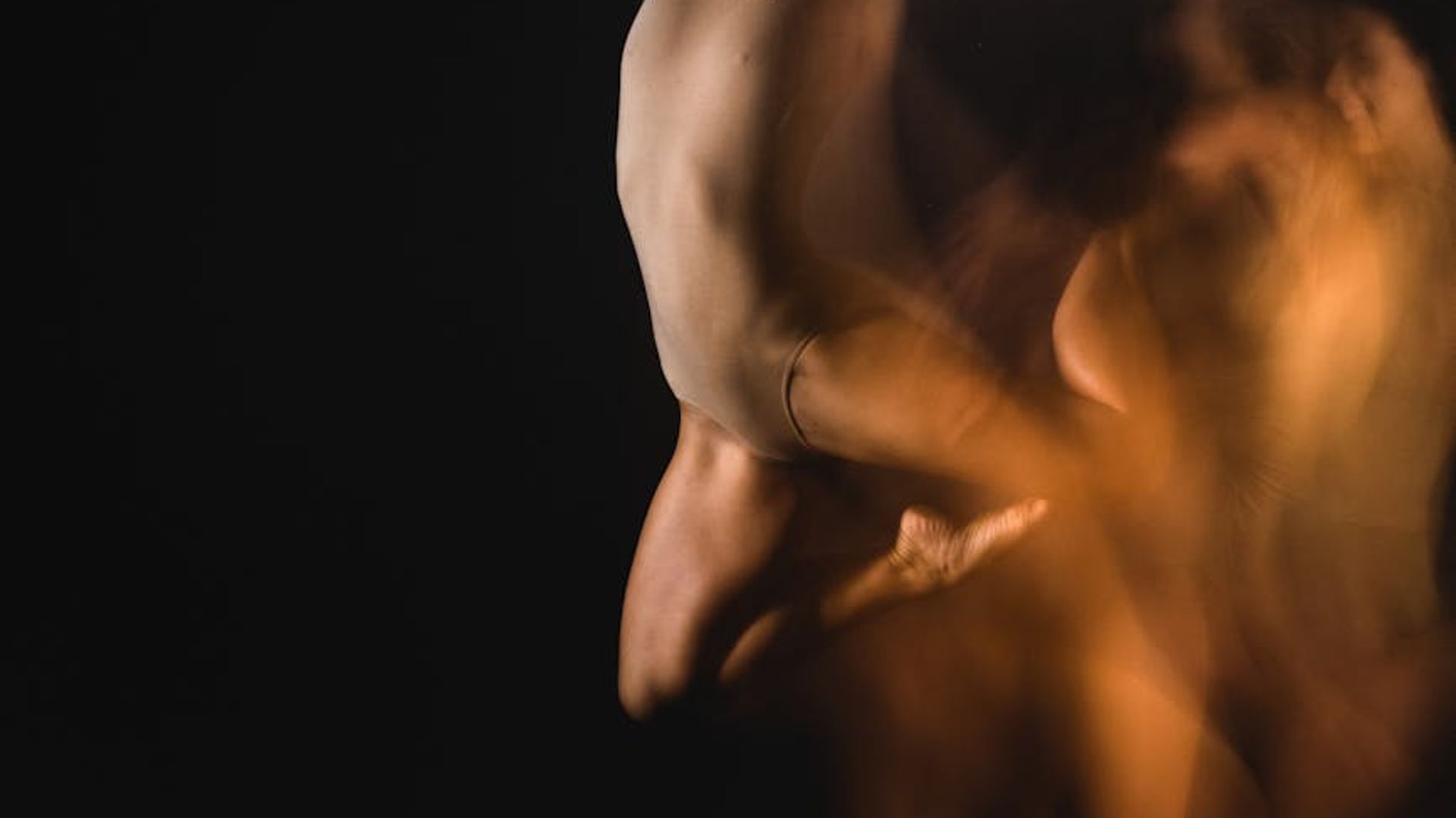Active person moving in a dark studio with blue light.